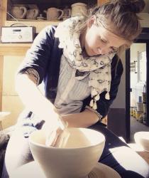 Ana Simmons, Teacher of Ceramics, throwing a bowl on a potters' wheel